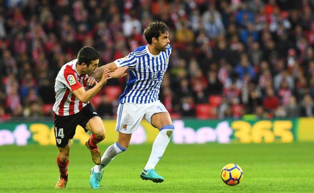 Xabi Prieto trata de zafarse del acoso del rojiblanco Susaeta en el derbi de este sábado en San Mamés. / JOSE MARI LÓPEZ