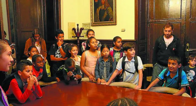 Los niños y niñas de las colonias de Adiskidetuak escuchando explicaciones sobre la Sala de Comisiones.