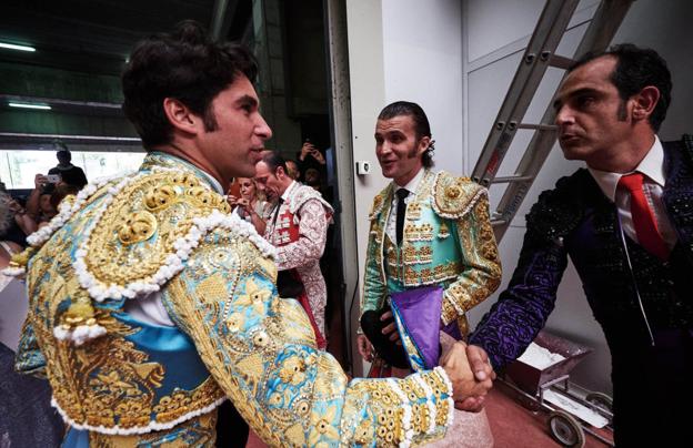 En presencia del sobresaliente David Saleri (verde lima y oro), Cayetano (azul celeste y oro) saluda en el callejón a David Casanova (nazareno y azabache), auxiliador de Pablo Hermoso de Mendoza.