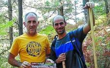 Organización. Asier Rosado y Koldo Arana preparando el recorrido de la prueba de enduro con las azadas y los rastrillos a mano. /