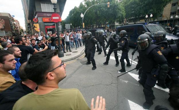 Agentes de la policía nacional forman un cordón policial en el exterior del IES de Tarragona./Efe