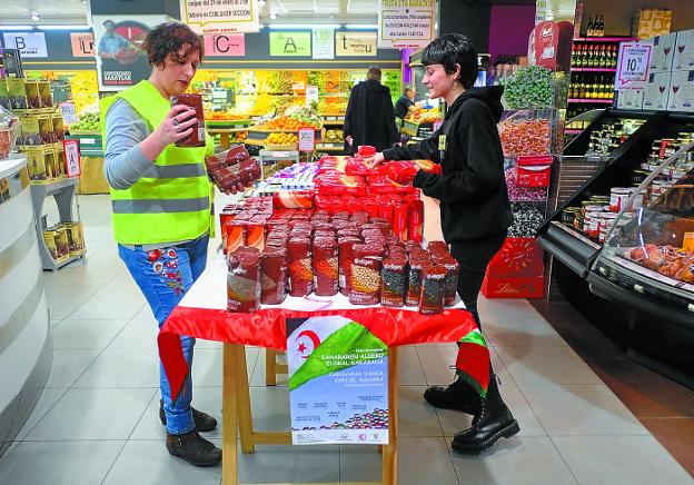 Solidarias. Dos voluntarias colocan los alimentos de la campaña en el Super Amara de Irun. / F. DE LA HERA