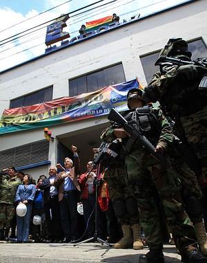 El vicepresidente boliviano habla junto a autoridades que custodian una de las principales oficinas de la distribuidora Electropaz./ M. Alipaz (Efe)/
