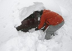 Una persona retira la nieve acumulada junto a un vehículo en la localidad de Roncesvalles. /EFE/
