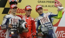 El ganador de la prueba de MotoGP de ayer, Casey Stoner, flanqueado en el podio por Lorenzo y Rossi. / AP/