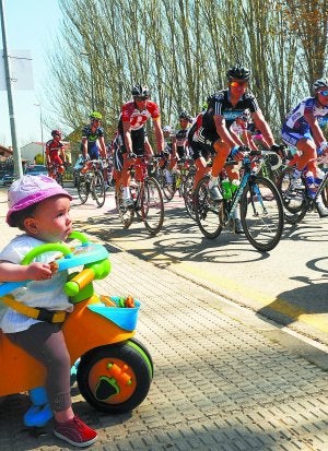 Un juego. Una niña observa el paso de los ciclistas, que le devuelven la mirada. ::
KARLIS/
