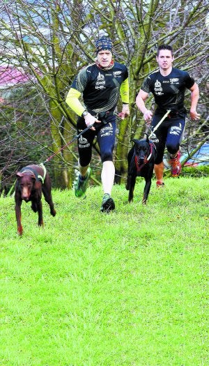 Patxi Azpiazu e Iker Paredes entrenando con sus dobermans, 'Betty' y 'Kaito'. :: ARIZMENDI/