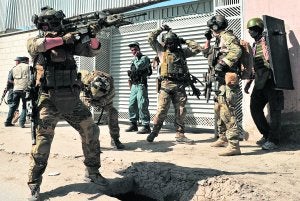 Un soldado afgano apunta su arma en dirección al edificio que tomaron ayer los talibanes en Kabul. ::
AFP/