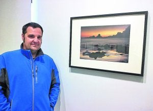 El fotógrafo vizcaíno, junto a una de sus obras que muestra en la sala Oxford. ::
ROMATET/