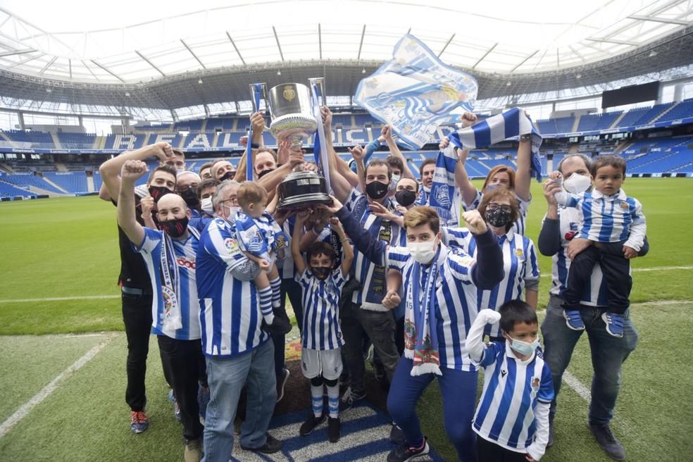 Afición. Seguidores de la Real levantan la Copa ayer en Anoeta bajo sonrisas, algo que se repetirá hoy con los jugadores. 