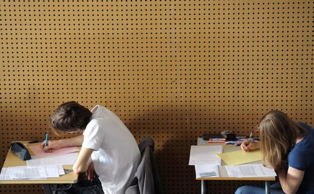 Apoyo escolar. Dos adolescentes realizan un examen en su centro de enseñanza. / AFP