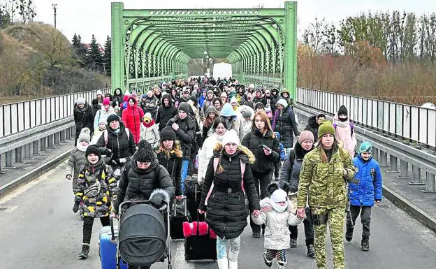 Hundreds of refugees cross the bridge that separates the border between Ukraine and Poland.
