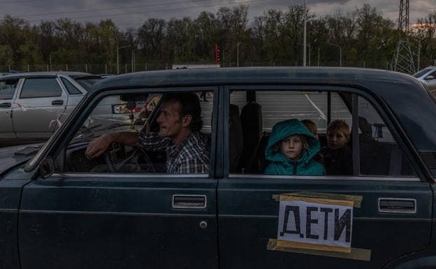 A family from Mariupol arrives in Zaporizhia in a car with a sign announcing the presence of children. 