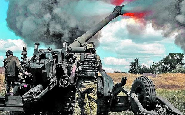 Ukrainian soldiers fire a cannon on the front lines of the Donbas region