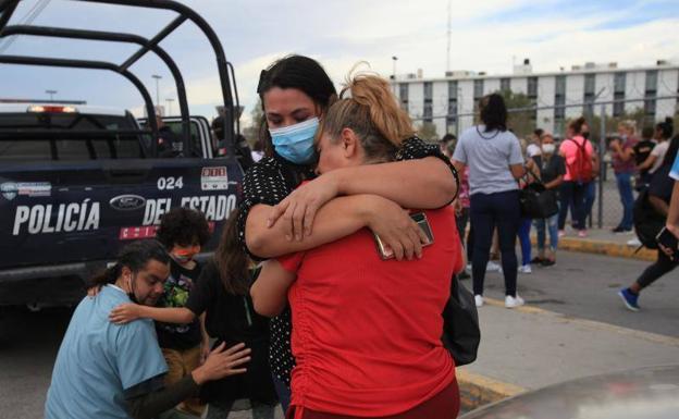 Relatives of inmates of the prison where the confrontation began embrace outside the center
