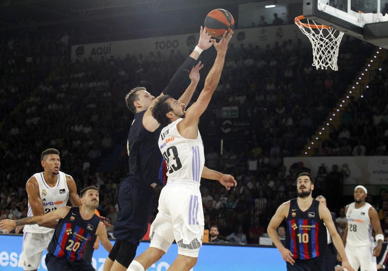 A Barça player tries to block Sergio Llull's shot to the basket