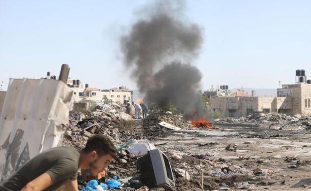 A Palestinian takes cover during clashes with Israeli troops in Jenin. 