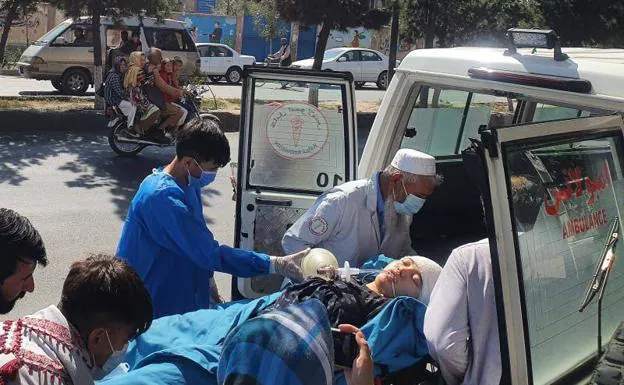 Medical personnel evacuate a young woman injured after the suicide attack on a school, this Friday in Kabul.