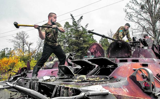 Ukrainian soldiers destroy Russian tanks abandoned by fleeing Kremlin soldiers. 