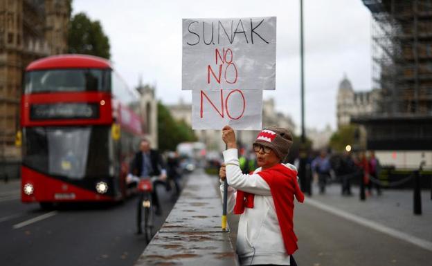 A woman demonstrates in London against a possible candidacy of Rishi Sunak. 