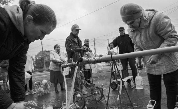 Residents of Mykolaiv line up to fill their jugs.