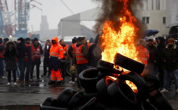 Workers at the refinery located in the port of Saint-Nazaire burn tires. 